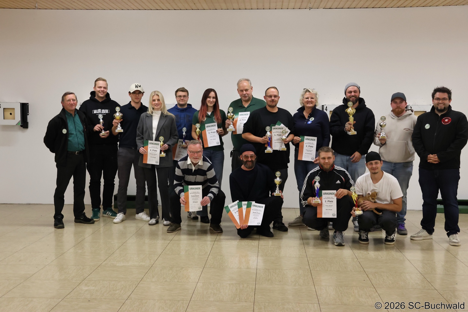 Gruppenfoto beim Vereins- und Betriebspokalschießen: Teilnehmende mit Pokalen und Urkunden.